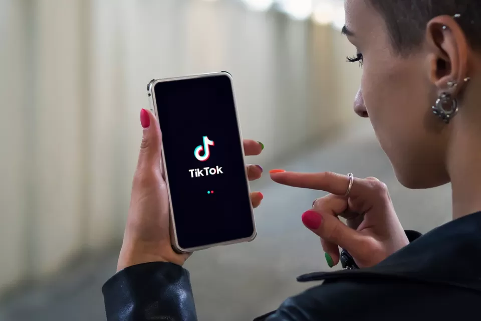 Woman holding phone with TikTok logo